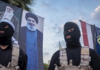 Guardie Rivoluzionarie iraniane sotto i ritratti della Guida Suprema Khamenei e leader di Hezbollah, Nasrallah